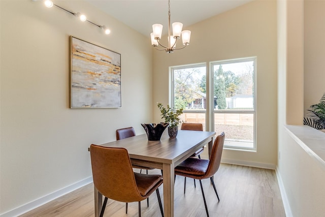 dining area featuring a notable chandelier, a healthy amount of sunlight, and light wood-type flooring