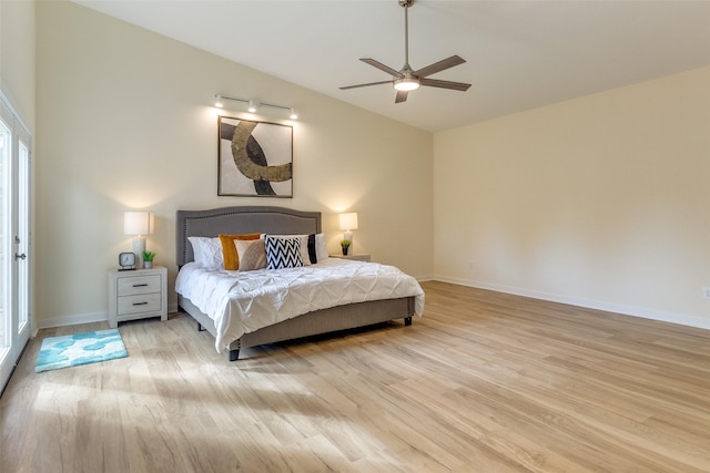 bedroom with ceiling fan, vaulted ceiling, and light hardwood / wood-style flooring