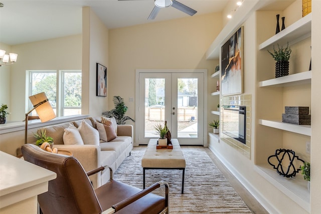 living room with built in shelves, a wealth of natural light, and light hardwood / wood-style flooring