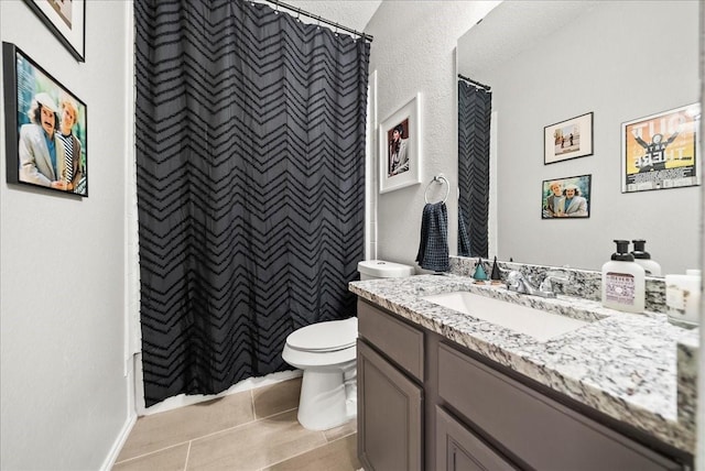 bathroom featuring tile patterned flooring, vanity, a shower with shower curtain, and toilet