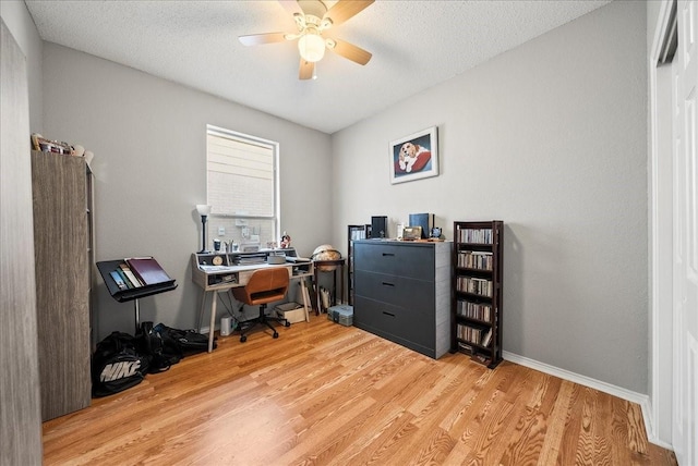 office space featuring a textured ceiling, light hardwood / wood-style floors, and ceiling fan