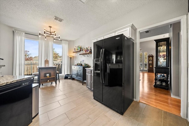 kitchen featuring white cabinetry, a chandelier, light hardwood / wood-style flooring, a textured ceiling, and black appliances