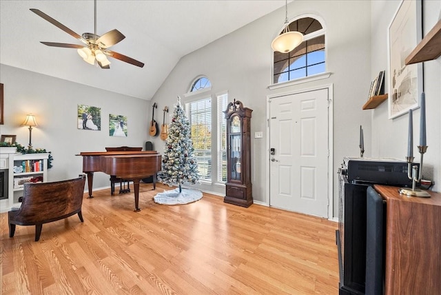 foyer entrance featuring ceiling fan, high vaulted ceiling, and light wood-type flooring