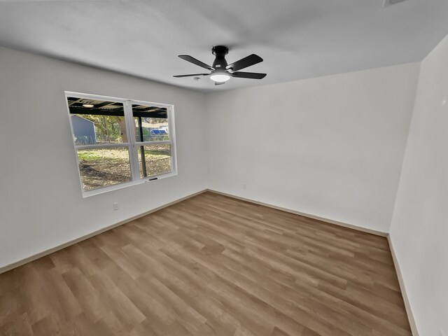 unfurnished bedroom featuring multiple windows, ceiling fan, and light wood-type flooring