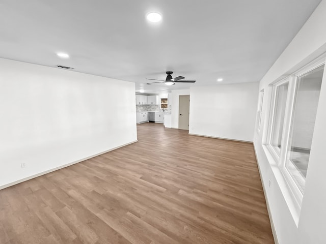 unfurnished living room with ceiling fan and wood-type flooring