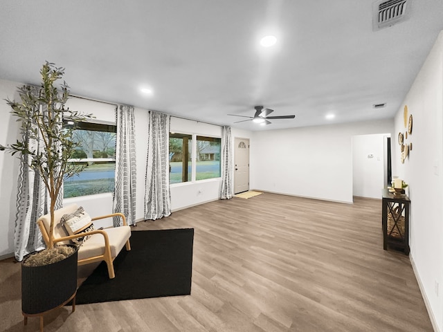 living area featuring ceiling fan and light hardwood / wood-style flooring