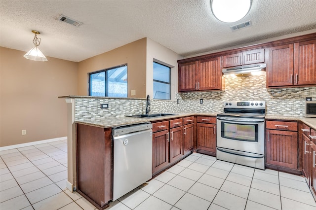 kitchen with sink, backsplash, decorative light fixtures, light tile patterned floors, and appliances with stainless steel finishes