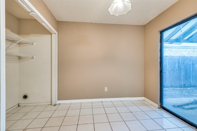 interior space with light tile patterned flooring and a textured ceiling