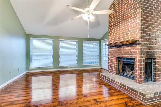 unfurnished living room featuring hardwood / wood-style floors, ceiling fan, lofted ceiling, and a brick fireplace