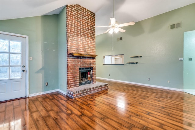 unfurnished living room with wood-type flooring, high vaulted ceiling, a brick fireplace, and ceiling fan