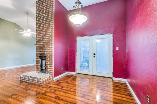 entryway featuring a fireplace, hardwood / wood-style floors, french doors, and ceiling fan