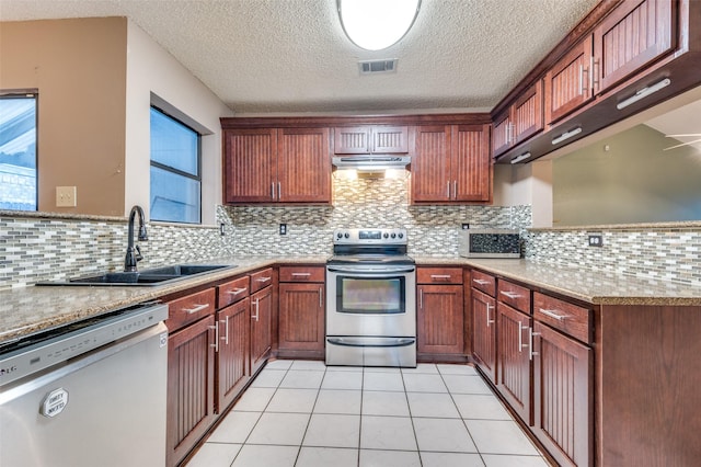 kitchen featuring appliances with stainless steel finishes, backsplash, light tile patterned floors, and sink