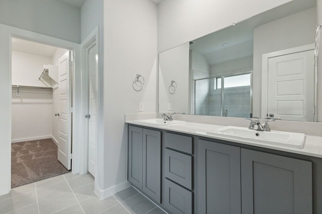 bathroom with tile patterned flooring, vanity, and walk in shower