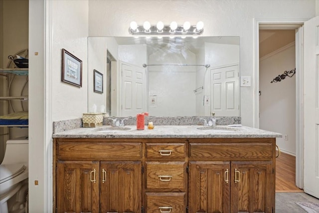 bathroom featuring wood-type flooring, vanity, and toilet