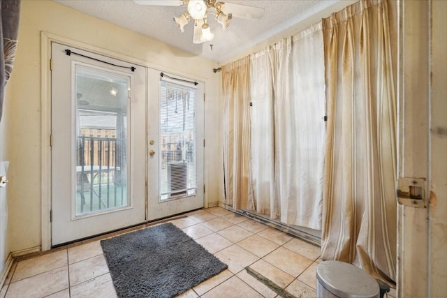 entryway with light tile patterned floors, french doors, a textured ceiling, and ceiling fan