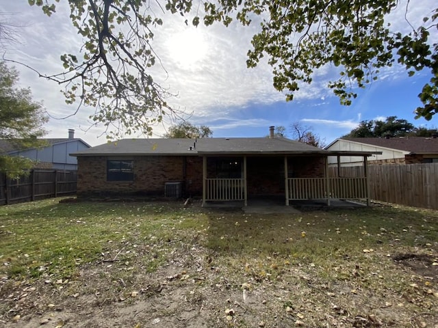 rear view of property featuring a yard and central air condition unit