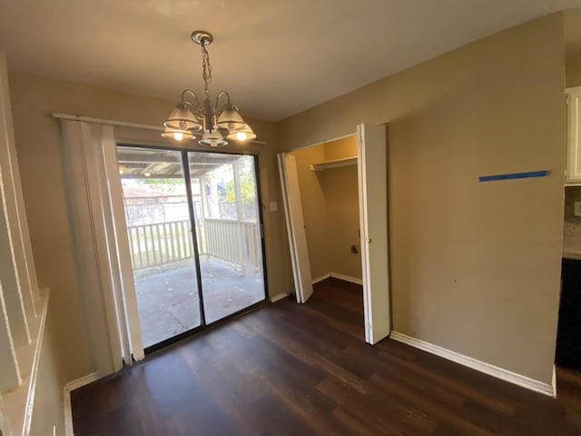 unfurnished dining area featuring dark hardwood / wood-style flooring and an inviting chandelier