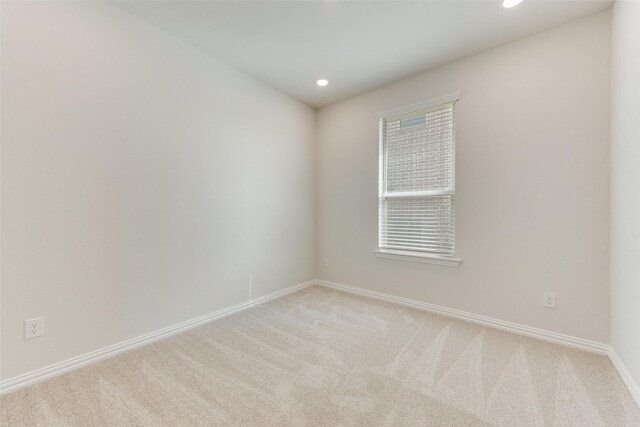 unfurnished room featuring light carpet