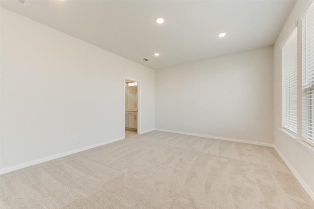 unfurnished room featuring light carpet