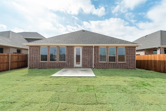 rear view of property with a lawn and a patio