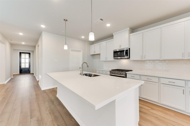 kitchen featuring white cabinetry, an island with sink, and appliances with stainless steel finishes