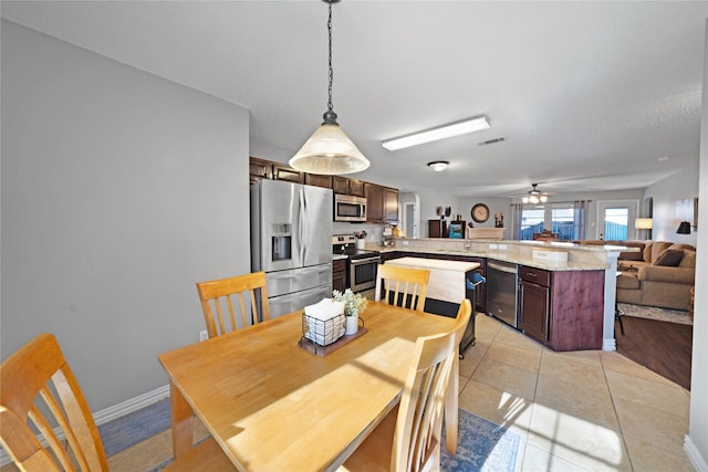 tiled dining area with ceiling fan and a textured ceiling