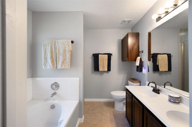 bathroom featuring vanity, a textured ceiling, tile patterned flooring, toilet, and a tub