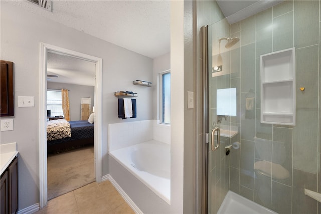 bathroom with tile patterned flooring, vanity, a textured ceiling, and independent shower and bath