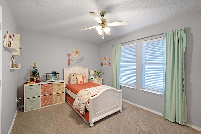 carpeted bedroom featuring ceiling fan and a textured ceiling