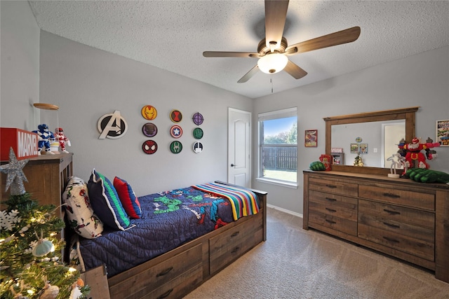 bedroom with ceiling fan, carpet, and a textured ceiling