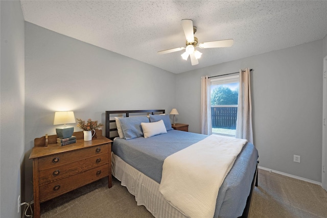 bedroom with dark colored carpet, a textured ceiling, and ceiling fan