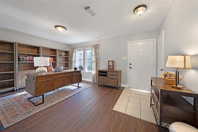 home office with a textured ceiling and dark wood-type flooring