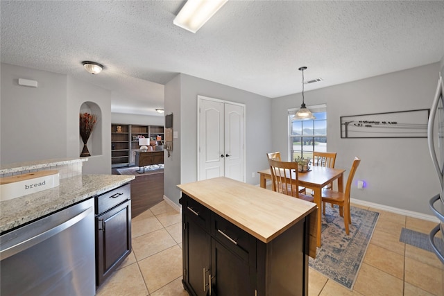 kitchen with dark brown cabinets, a textured ceiling, pendant lighting, dishwasher, and a kitchen island