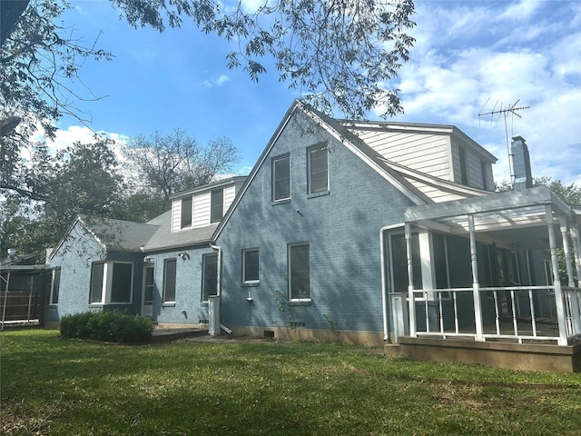 back of house featuring a yard and a sunroom