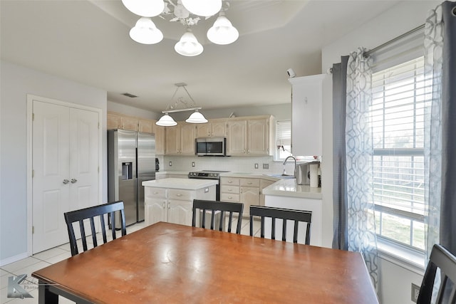 dining area featuring a notable chandelier, sink, and light tile patterned floors