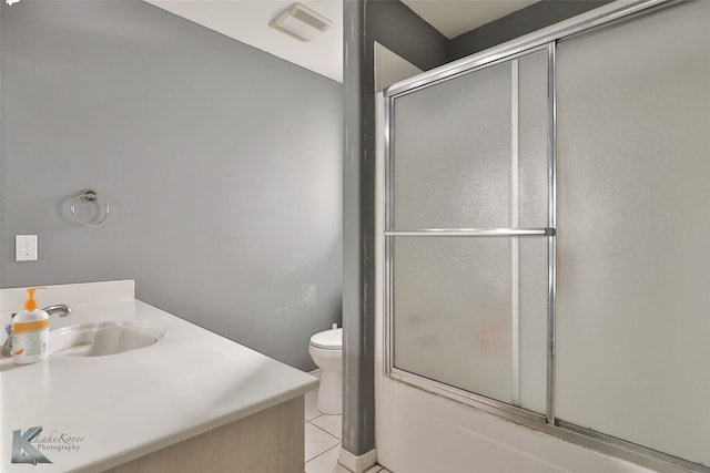 full bathroom with enclosed tub / shower combo, vanity, tile patterned floors, and toilet