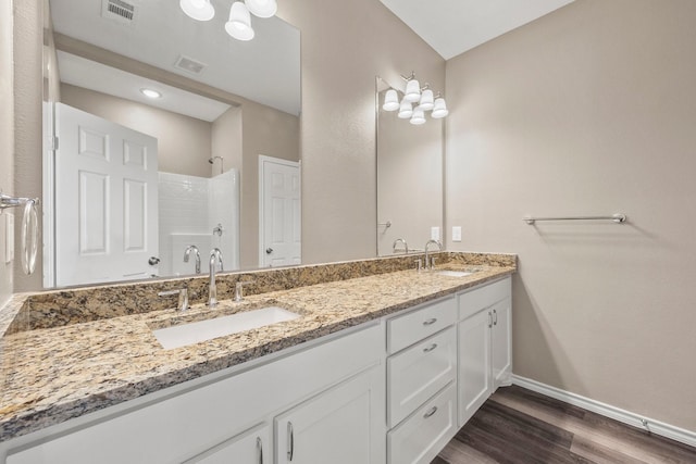 bathroom featuring vanity, wood-type flooring, and a shower