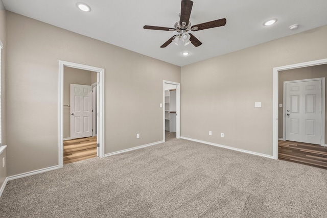 unfurnished bedroom featuring ceiling fan, a walk in closet, carpet floors, and a closet