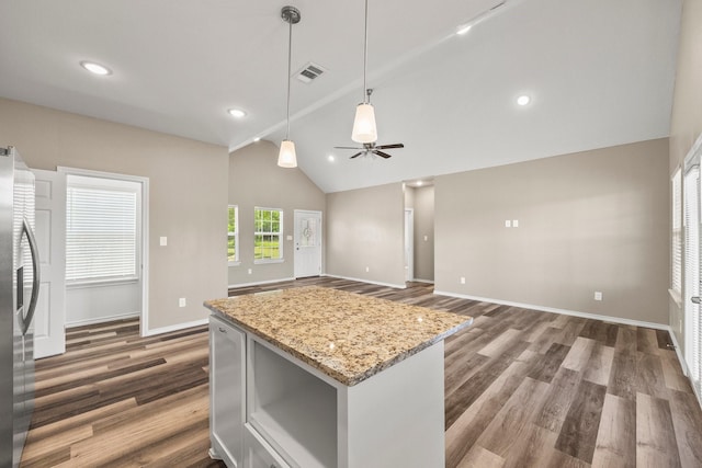 kitchen featuring lofted ceiling, visible vents, dark wood-style floors, baseboards, and stainless steel fridge