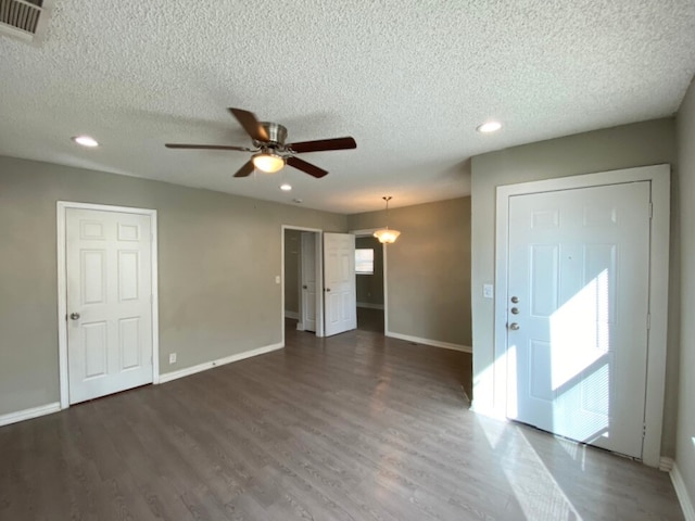 interior space with ceiling fan, dark hardwood / wood-style flooring, and a textured ceiling