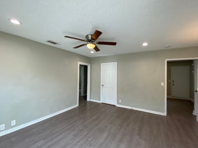 unfurnished room featuring ceiling fan, dark hardwood / wood-style floors, and a textured ceiling