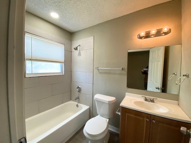 full bathroom with vanity, a textured ceiling, toilet, and tiled shower / bath