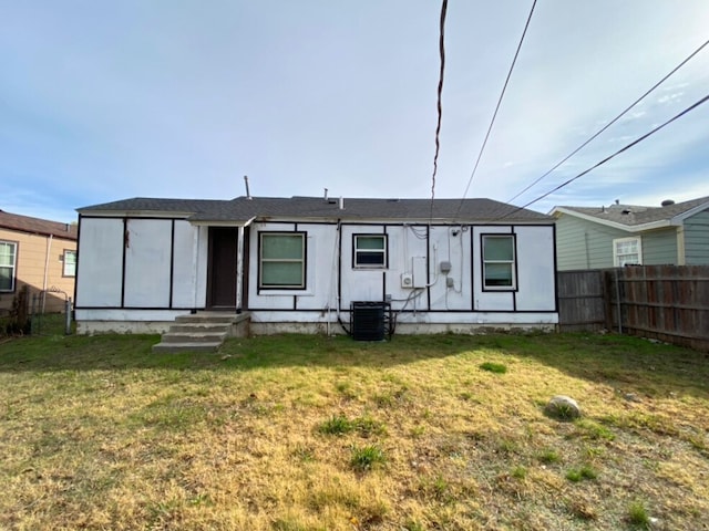 back of house with central AC and a yard