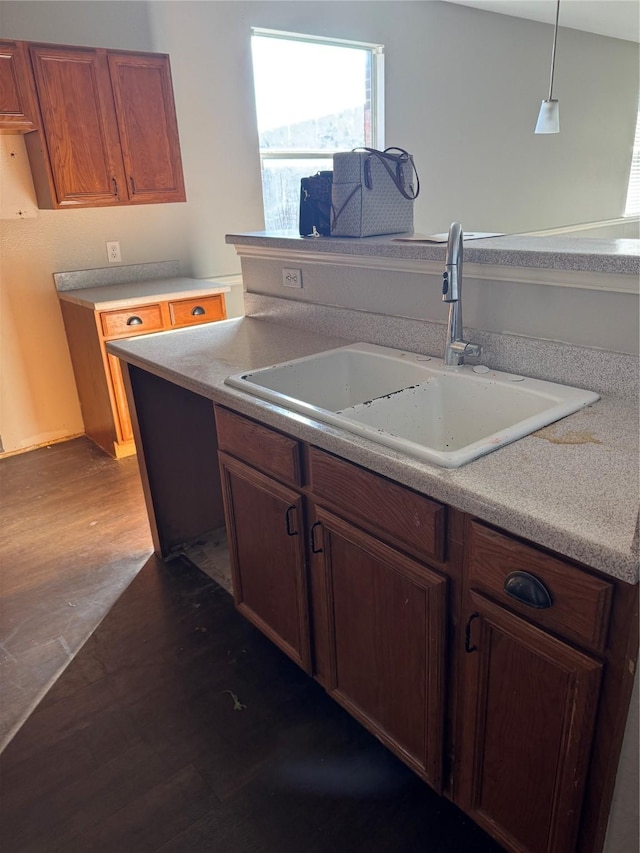 kitchen with dark hardwood / wood-style floors, sink, and hanging light fixtures