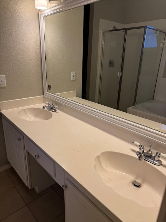 bathroom featuring a shower with door, vanity, and tile patterned flooring