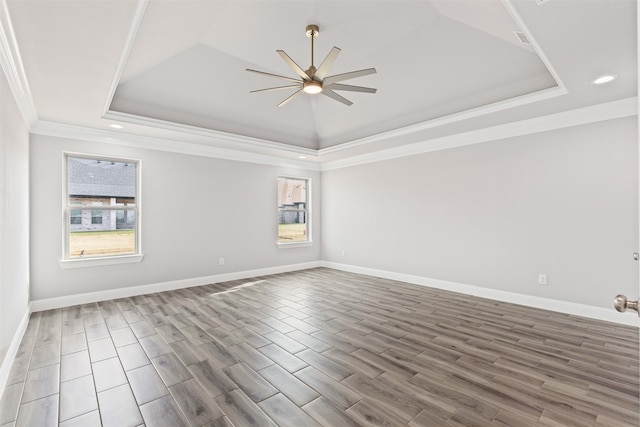 unfurnished room featuring hardwood / wood-style flooring, ceiling fan, crown molding, and a tray ceiling