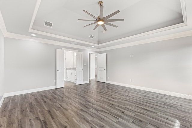 unfurnished room featuring hardwood / wood-style floors, ceiling fan, and a raised ceiling