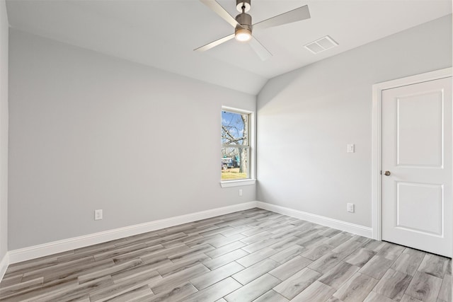 empty room featuring ceiling fan, vaulted ceiling, and light hardwood / wood-style flooring