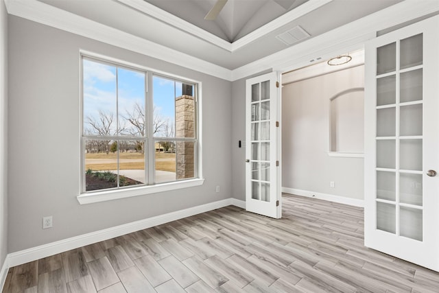 empty room featuring french doors, light hardwood / wood-style floors, lofted ceiling, and ornamental molding