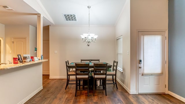 dining space with dark hardwood / wood-style flooring, ornamental molding, and a chandelier